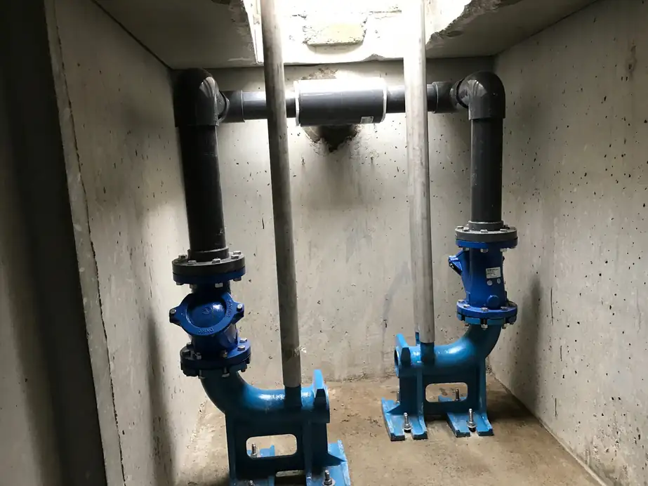 A septic pump vault showing blue pump bases and black discharge pipes